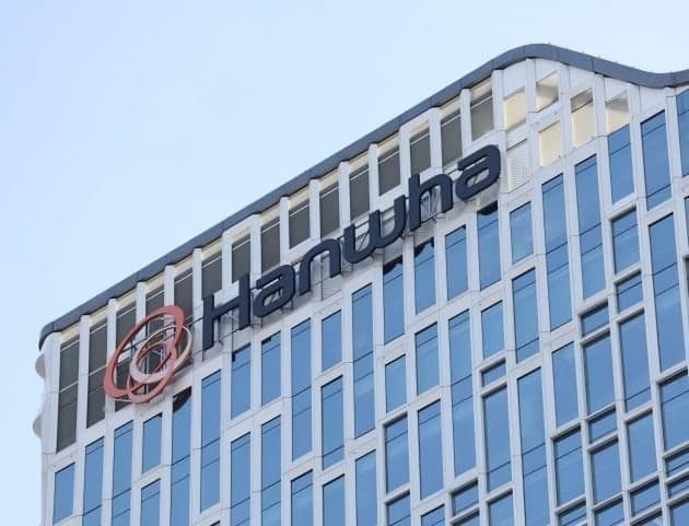 The Hanwha logo and lettering mounted on the upper floors of a glass office tower