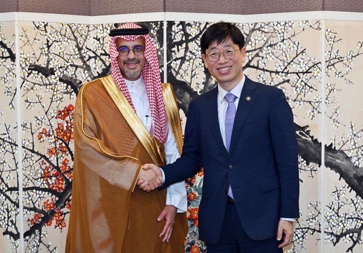 KASA Administrator Oh Tae-seok shaking hands with Saudi official Haitham AlOhali in front of a painted folding screen