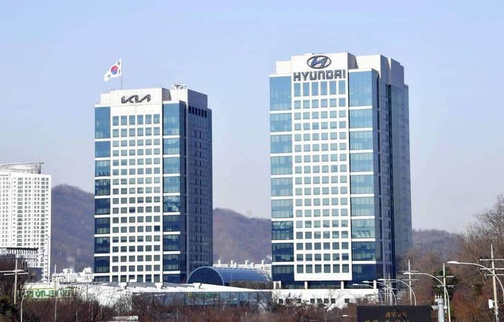 The Hyundai Motor and Kia headquarters towers in Seoul under a clear sky.
