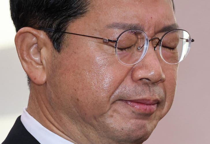 Justice minister nominee Kim Seung-won stands with his eyes closed and head bowed.