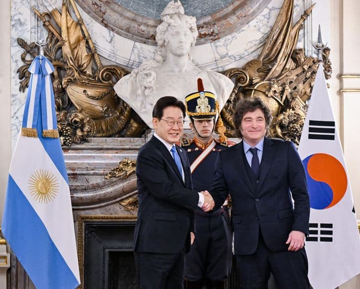 President Lee Jae-myung shakes hands with Argentine President Javier Milei between the two nations' flags at the Casa Rosada in Buenos Aires.