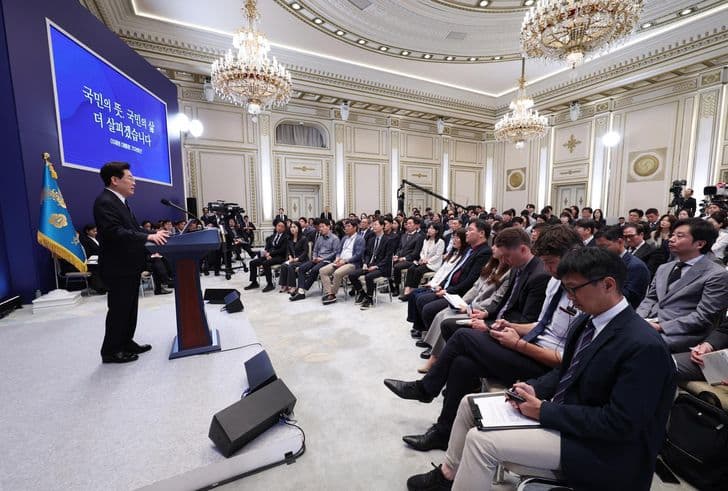 President Lee Jae-myung speaks at a podium in front of an audience seated in a grand hall.