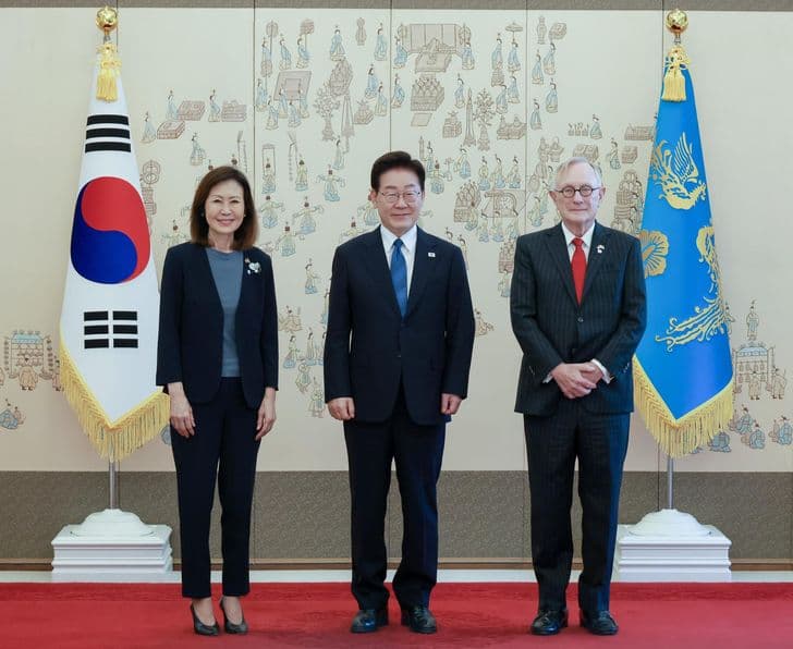 President Lee Jae-myung stands between US Ambassador Michelle Steel and her husband before the Korean flag and the presidential standard.