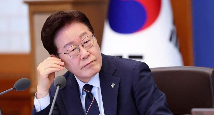 President Lee Jae-myung rests a hand near his face with a pensive expression during a meeting.