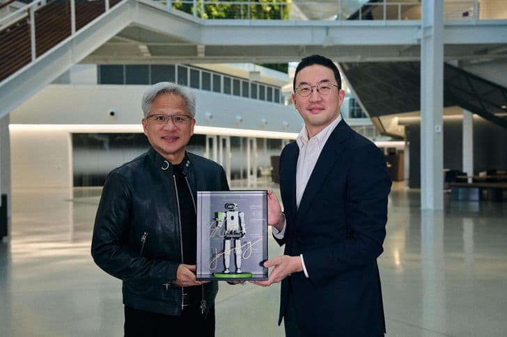 Nvidia CEO Jensen Huang and LG Chairman Koo Kwang-mo hold a framed robot figure together.
