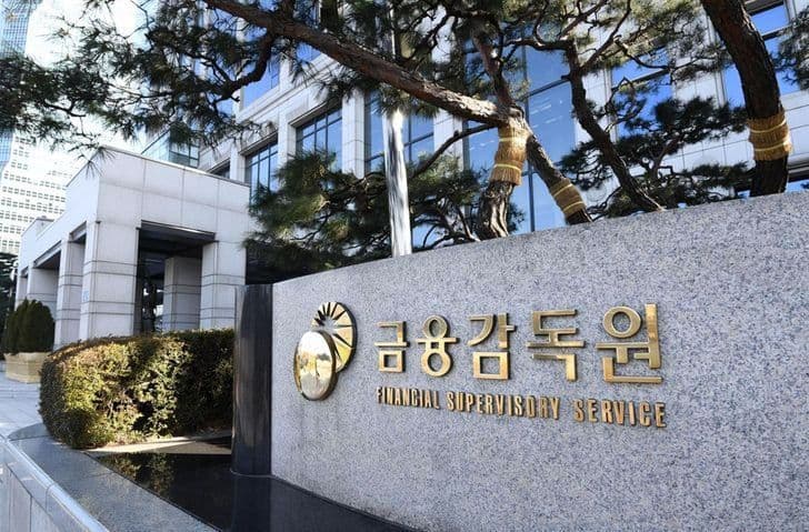 A granite marker with the Financial Supervisory Service name in Korean and English stands in front of the agency's building in Seoul.