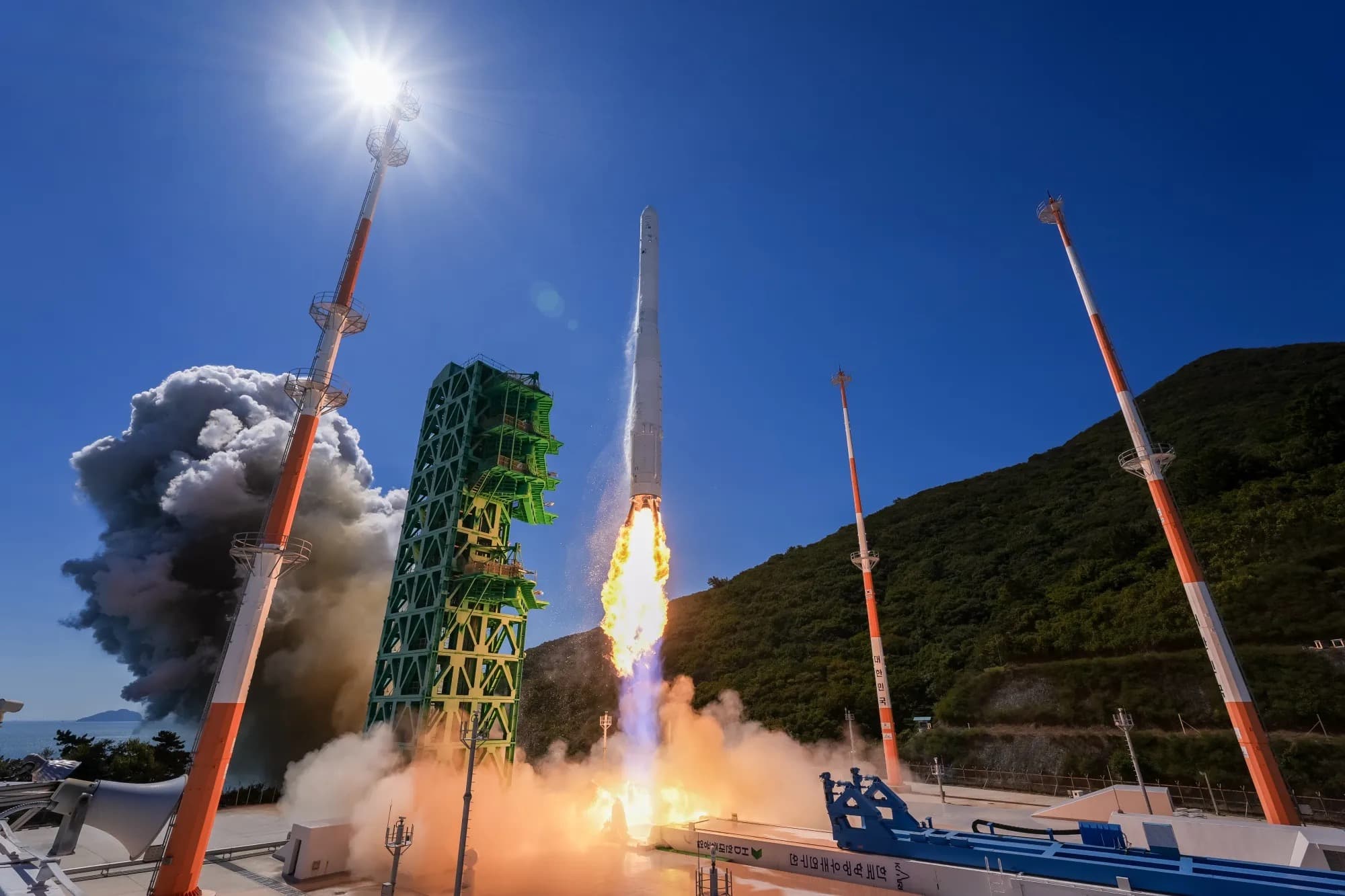 The Nuri rocket lifts off from its launch pad in a burst of flame and smoke.