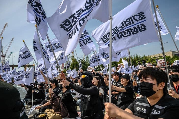 Workers wave white flags at an outdoor union rally.